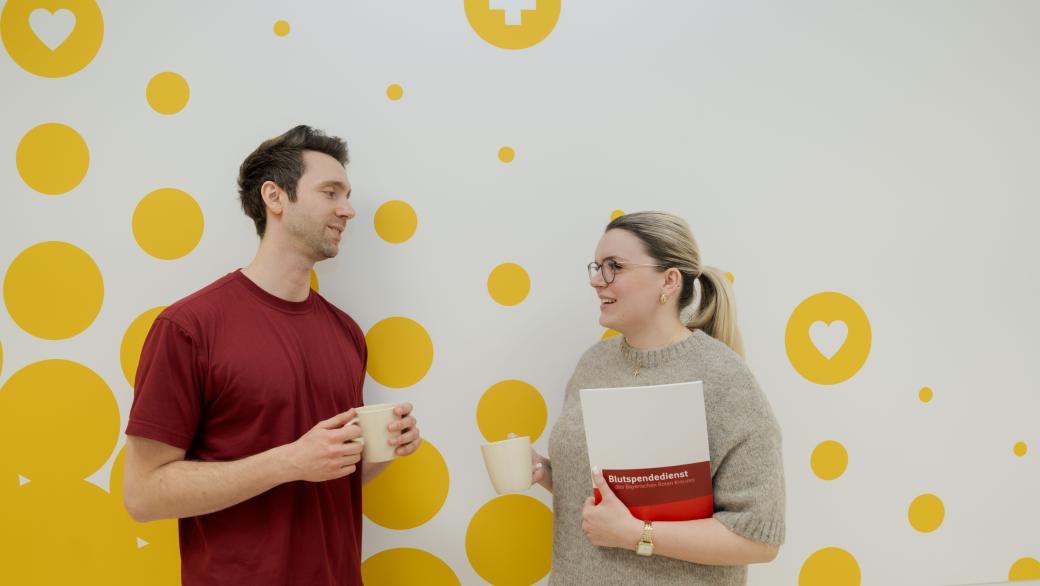 Mitarbeiter und Mitarbeiterin unterhalten sich auf dem Flur